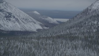 4K aerial stock footage flying by Saint Anne Lake, snow-covered slopes, during winter, Chugach Mountains, Alaska Aerial Stock Footage | AK0001_0956