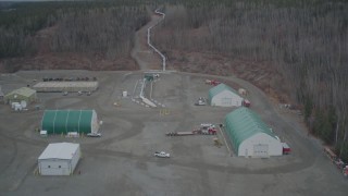 AK0001_1010 - 4K aerial stock footage fly over buildings pipeline rising from ground, winter, Trans-Alaska Pipeline, Alaska