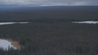 4K aerial stock footage flying past snow covered lakes in the forest in the Alaskan Wilderness Aerial Stock Footage | AK0001_1014