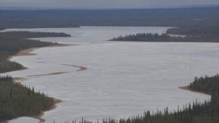 4K aerial stock footage ice and snow covered Sucker Lake surrounded by forest, Alaska Aerial Stock Footage | AK0001_1031