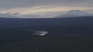 4K aerial stock footage flying over forest toward the Tazlina River and snow capped mountains, Alaska Aerial Stock Footage | AK0001_1045