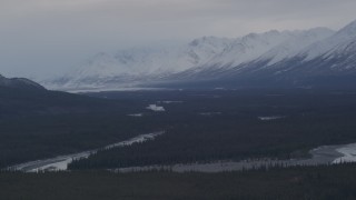 AK0001_1046 - 4K aerial stock footage flying alongside Tazlina River, forest and snow capped mountains, Alaska