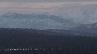 4K aerial stock footage wooded hills near lake, snow capped Chugach Mountains, Alaskan Wilderness Aerial Stock Footage | AK0001_1049