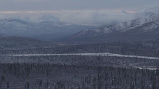 4K aerial stock footage snow capped Talkeetna Mountains and wooded foothills, Alaskan Wilderness Aerial Stock Footage | AK0001_1054