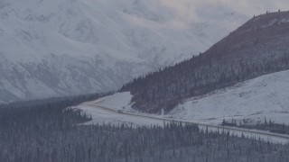 4K aerial stock footage Glenn Highway winding around snowy Talkeetna Mountain, Alaskan Wilderness Aerial Stock Footage | AK0001_1055