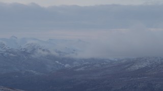 AK0001_1058 - 4K aerial stock footage low clouds eclipsing snowy Talkeetna Mountains, Alaska