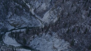 AK0001_1065 - 4K aerial stock footage a river at bottom of wooded, snowy canyon, Talkeetna Mountains, Alaska