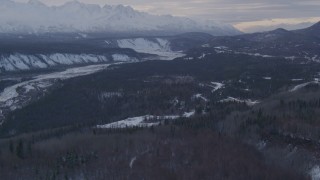 AK0001_1074 - 4K aerial stock footage a snowy, wooded slope, revealing Sutton, Matanuska River Valley, Alaska