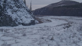 AK0001_1077 - 4K aerial stock footage flying low over surface of Matanuska River and snow covered shore, Alaska