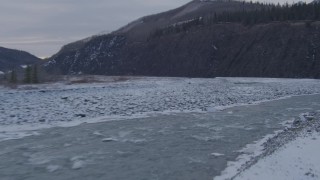 AK0001_1078 - 4K aerial stock footage following the Matanuska River and snow covered shore, Alaska