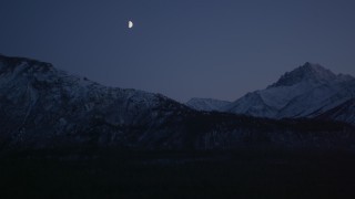 4K aerial stock footage the moon over the snow covered Chugach Mountains at night, Alaska Aerial Stock Footage | AK0001_1107