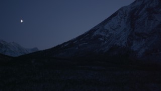 AK0001_1112 - 4K aerial stock footage the moon over the snow covered Chugach Mountains at night, Alaska