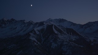 4K aerial stock footage the moon over the snow covered Chugach Mountains at night, Alaska Aerial Stock Footage | AK0001_1123