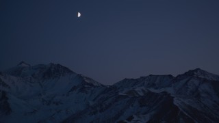 4K aerial stock footage the moon over the snow covered Chugach Mountains at night, Alaska Aerial Stock Footage | AK0001_1126