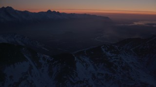 4K aerial stock footage approach river valley, snow covered Chugach Mountains, Alaska, twilight Aerial Stock Footage | AK0001_1136