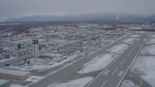 4K aerial stock footage lift off from snowy Merrill Field, head across East 5th Ave, Anchorage, Alaska Aerial Stock Footage | AK0001_1147