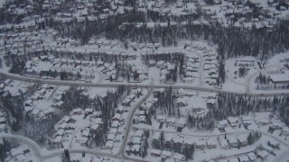 4K aerial stock footage flying over snow covered neighborhoods and trees in Eagle River, Alaska Aerial Stock Footage | AK0001_1161