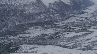 4K aerial stock footage tilting to snowy, forested valley at base of Chugach Mountains, Alaska Aerial Stock Footage | AK0001_1175