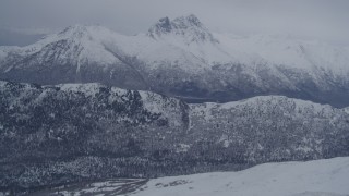 4K aerial stock footage flying toward rocky, snow covered Chugach Mountain peak, Alaska Aerial Stock Footage | AK0001_1179