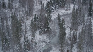 4K aerial stock footage flying low over river through snow covered forest, Chugach Mountains, Alaska Aerial Stock Footage | AK0001_1201