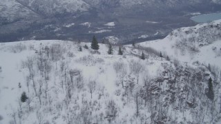 4K aerial stock footage flying toward snowy summit, revealing wooded valley, Chugach Mountains, Alaska Aerial Stock Footage | AK0001_1204