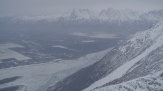 AK0001_1210 - 4K aerial stock footage Butte and Knik River Valley at base of snow covered Chugach Mountains, Alaska