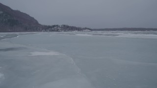 AK0001_1264 - 4K aerial stock footage following a river over ice sheets, Knik River Valley, Alaska in snow