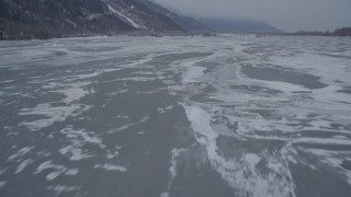 AK0001_1276 - 4K aerial stock footage flying over frozen ground and iced over rivers, Butte, Alaska