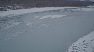 4K aerial stock footage flying over snow covered trees revealing icy river, Butte, Alaska Aerial Stock Footage | AK0001_1280