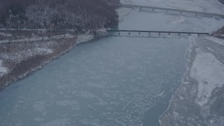 4K aerial stock footage fly over snowy shore, Glenn Highway, Highway 1 bridge, Knik River Valley, Alaska Aerial Stock Footage | AK0001_1301