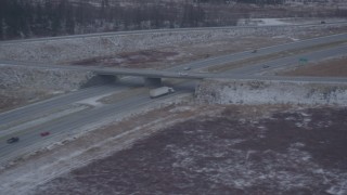 4K aerial stock footage light traffic on Glenn Highway by snow covered ground, Anchorage, Alaska Aerial Stock Footage | AK0001_1303