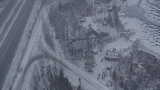 4K aerial stock footage flying over frozen lake, snowy houses, reveal Glenn Highway, Eagle River, Alaska Aerial Stock Footage | AK0001_1310