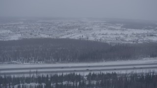 4K aerial stock footage tracking cars on Glenn Highway in falling snow, Fort Richardson, Anchorage, Alaska Aerial Stock Footage | AK0001_1320