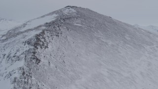 4K aerial stock footage flying up snow covered slope toward summit in the Chugach Mountains, Alaska Aerial Stock Footage | AK0001_1341