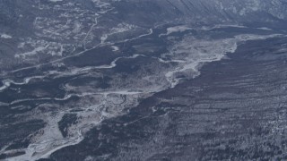 4K aerial stock footage tilting up along Eagle River revealing snow covered Chugach Mountains, Alaska Aerial Stock Footage | AK0001_1347