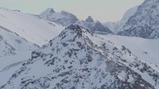 4K aerial stock footage flying over a rocky peak toward a snowy summit in Chugach Mountains, Alaska Aerial Stock Footage | AK0001_1351