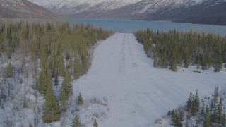 4K aerial stock footage descending toward strip of snowy ground by Eklutna Lake, Alaska Aerial Stock Footage | AK0001_1358