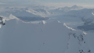 AK0001_1377 - 4K aerial stock footage flying over snowy ridge toward the Knik Glacier, Alaska