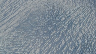 4K aerial stock footage tilt from the surface of the snow covered Knik Glacier, Alaska, reveal snowy mountains Aerial Stock Footage | AK0001_1385