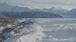 4K aerial stock footage flying along edge of snow covered Knik Glacier toward Chugach Mountains, Alaska Aerial Stock Footage | AK0001_1388