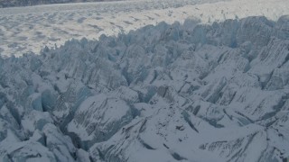 4K aerial stock footage flying over jagged, snow covered surface of Knik Glacier, Alaska Aerial Stock Footage | AK0001_1416