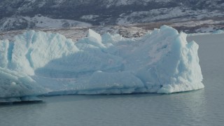 AK0001_1434 - 4K aerial stock footage orbiting a chunk of glacial ice in Inner Lake George, Alaska in snow