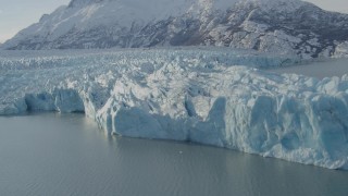 AK0001_1445 - 4K aerial stock footage flying toward edge of glacier on Inner Lake George, snow covered peak, Alaska