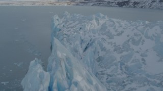 AK0001_1456 - 4K aerial stock footage flying along edge of snow covered glacier on Inner Lake George, Alaska