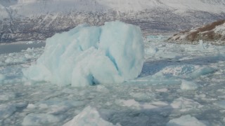 AK0001_1457 - 4K aerial stock footage snow covered Chugach Mountains, flying over icy Inner Lake George, Alaska