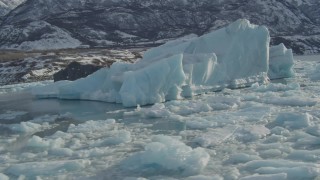 AK0001_1462 - 4K aerial stock footage orbiting large chunks of glacial ice on Inner Lake George, Alaska in snow