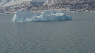 AK0001_1467 - 4K aerial stock footage flying over Inner Lake George toward piece of glacial ice, Alaska in snow