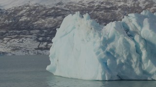 AK0001_1468 - 4K aerial stock footage orbiting a piece of glacial ice on Inner Lake George, Alaska in snow