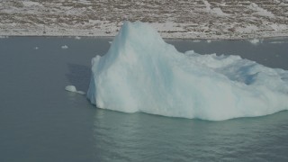 AK0001_1470 - 4K aerial stock footage flying toward piece of glacial ice on Inner Lake George, Alaska in snow