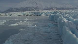 AK0001_1480 - 4K aerial stock footage flying over edge of snow covered glacier on Inner Lake George, Alaska